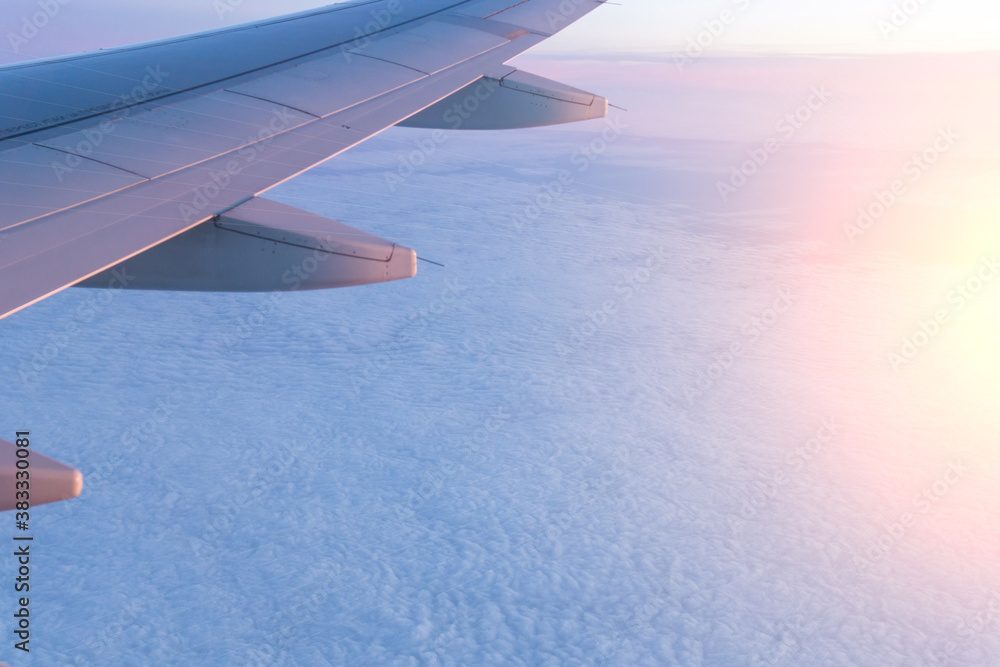 An aircraft wing above a sea of cloud at dawn