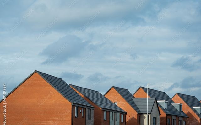 New-build houses under a clearing sky
