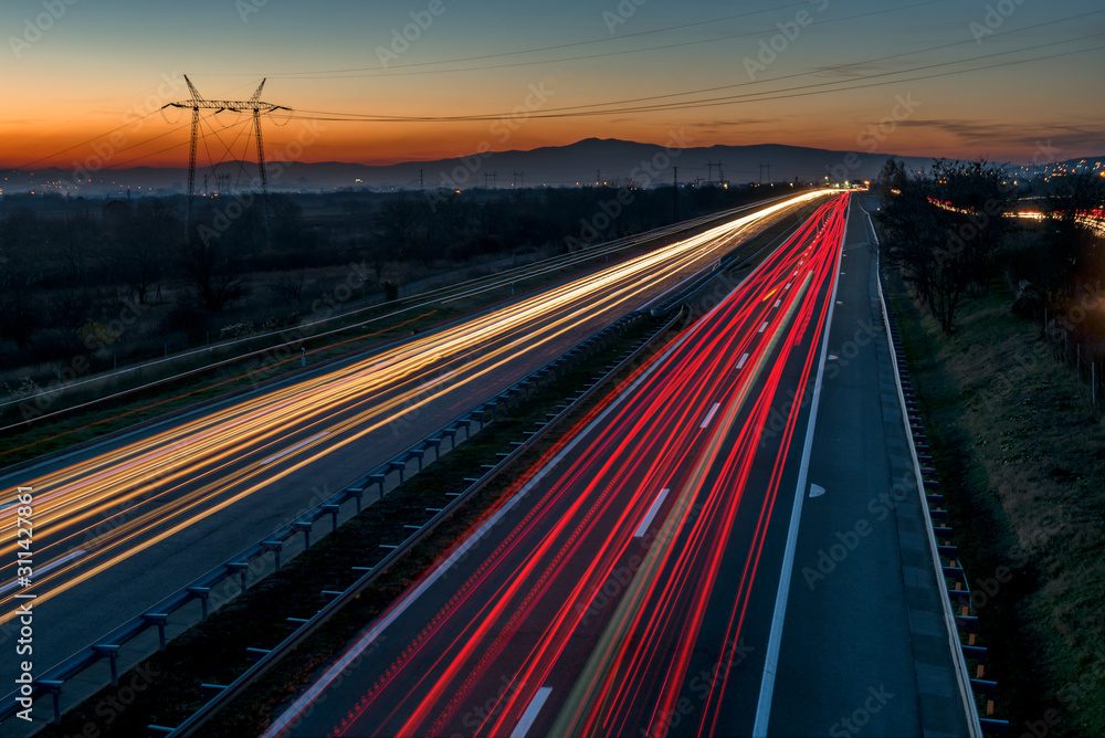 Light trails on a straight motorway at dusk