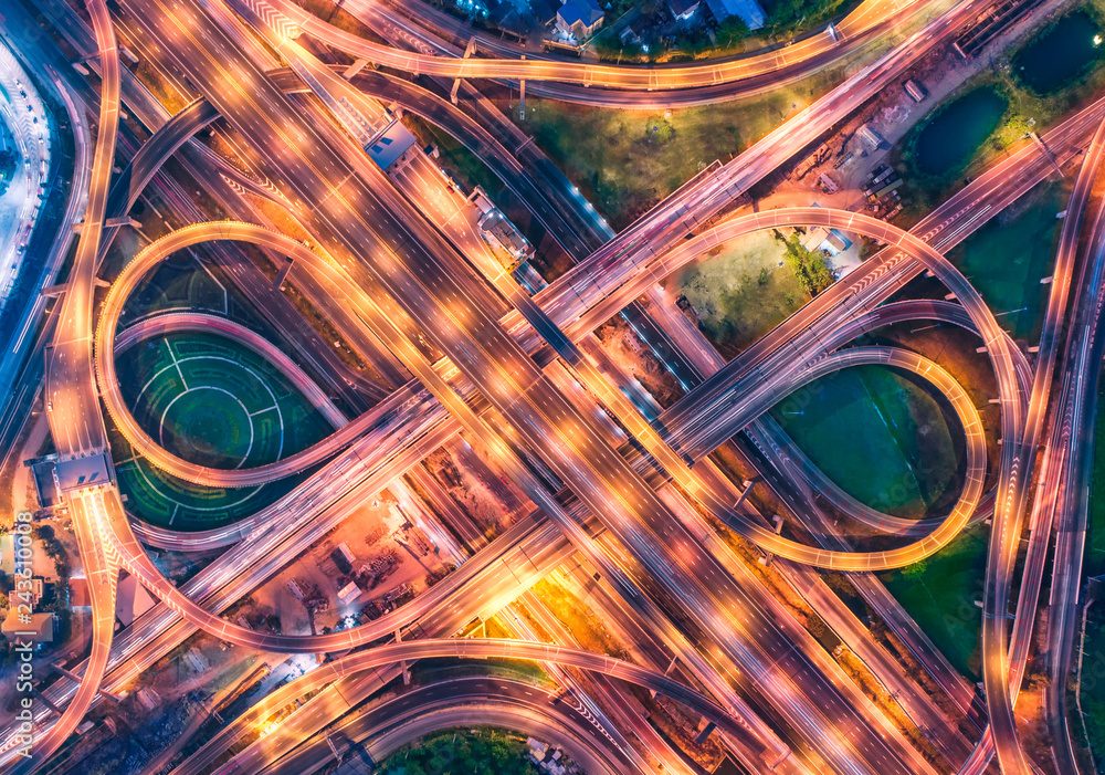 Light trails on a motorway interchange at night, from above